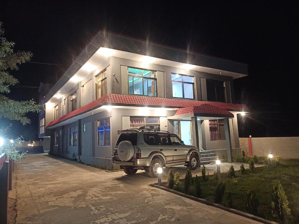 un suv garé devant une maison la nuit dans l'établissement Royal Resort Skardu, à Skardu