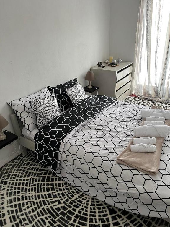 a bedroom with a large bed with black and white sheets at Tasos_Studios&Apartments in Kranidi