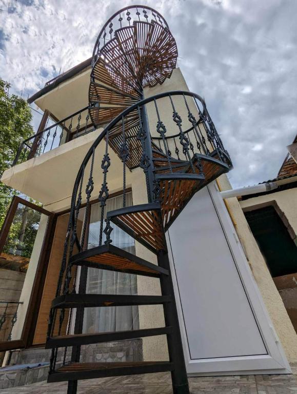 a spiral staircase in front of a house with a building at DATI in Borjomi