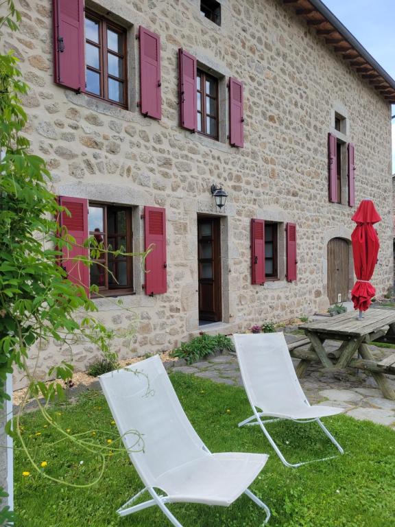 deux chaises et une table devant un bâtiment dans l'établissement Se reconnecter à la nature au gîte 3 étoiles de Montager à Saint André de Chalencon, à Saint-André-de-Chalençon