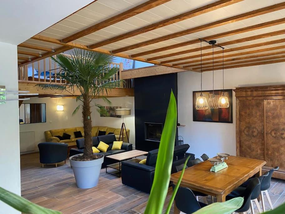 uma sala de estar com uma mesa e um sofá em Bienvenue à la Villa Plagnal Classée 3 étoiles em Aubière