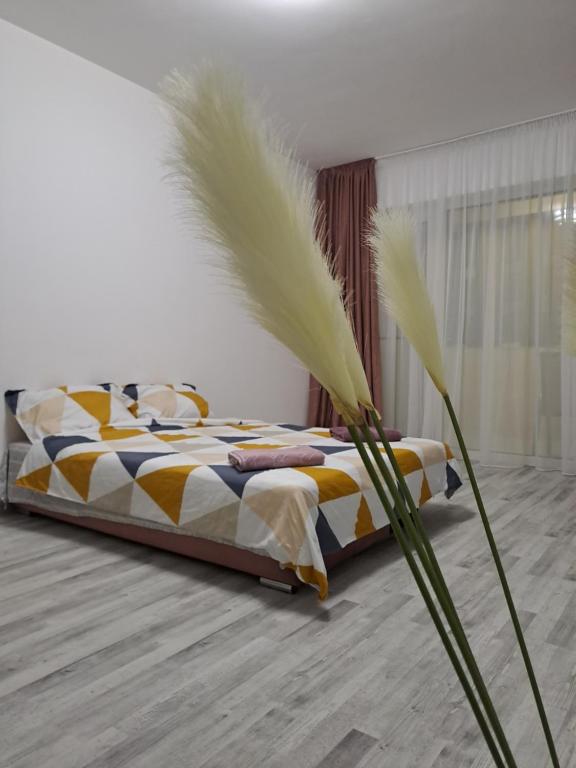 a bedroom with a bed with feathers on it at Happy Rental Apartments 2 in Craiova