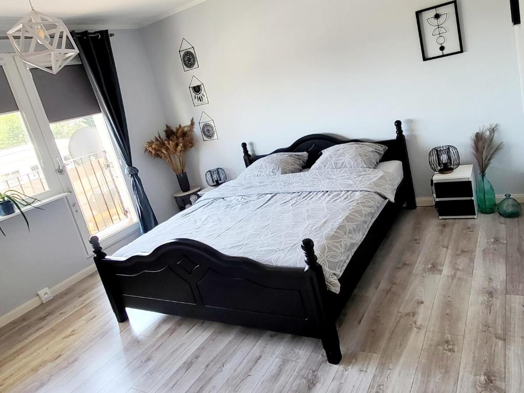 a bedroom with a black bed and a wooden floor at Przytulnie w Szczytnie in Szczytno