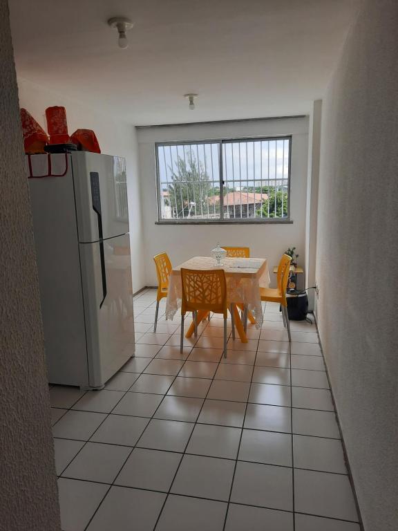 uma cozinha com uma mesa e um frigorífico em Apartamento por temporada em Fortaleza