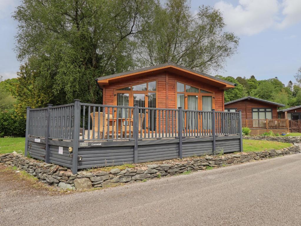 une petite cabine avec une clôture sur le côté d'une route dans l'établissement Cottontail Lodge, à Windermere