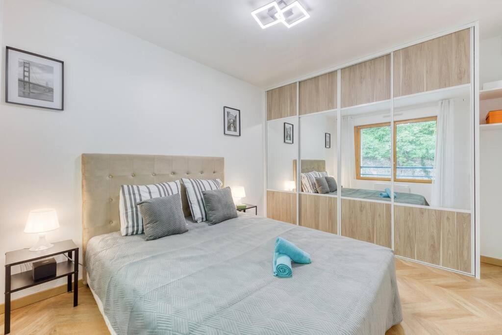 een witte slaapkamer met een groot bed en een raam bij Amazing apartment in a park overlooking Paris in Meudon