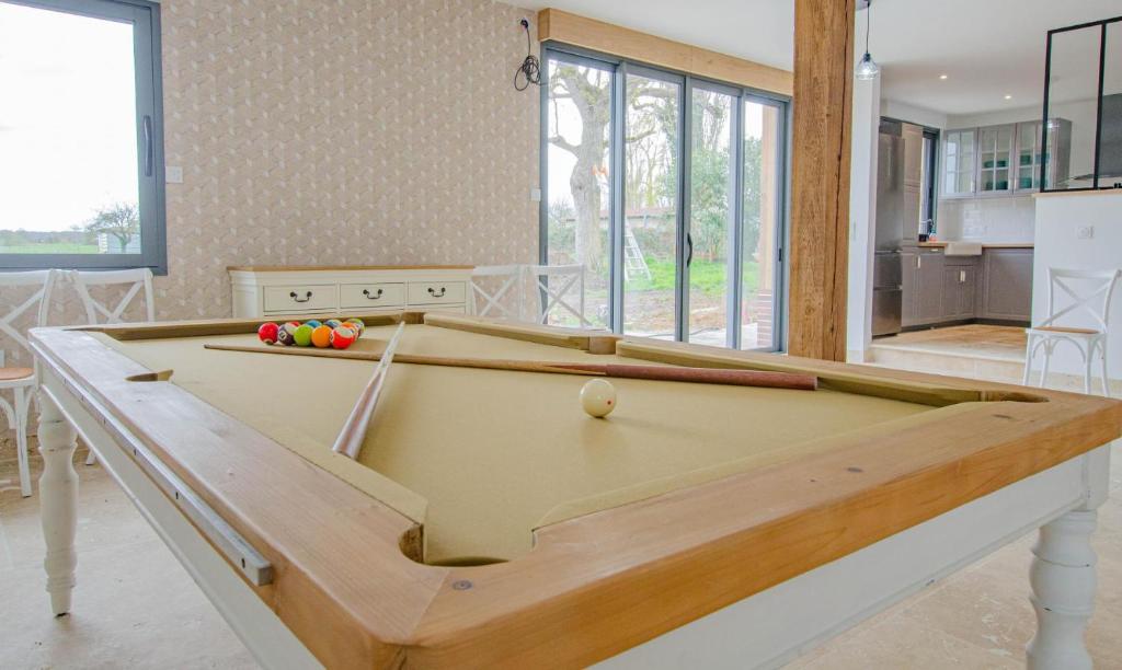 a ping pong table in a living room with a pool at Au naturel in Montreuil-sur-Barse