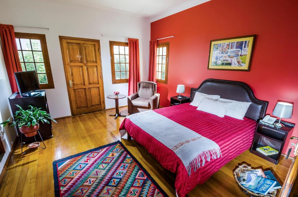 1 dormitorio rojo con 1 cama y 1 silla en Hotel Boutique Selva Alegre, en Arequipa