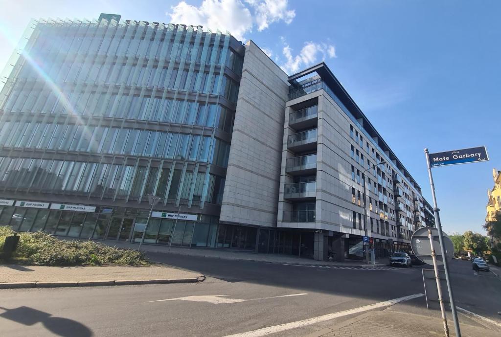 un edificio alto con un letrero de la calle delante de él en Boznicza Old Town LUX Apartment, self check-in 24h, free parking, en Poznan