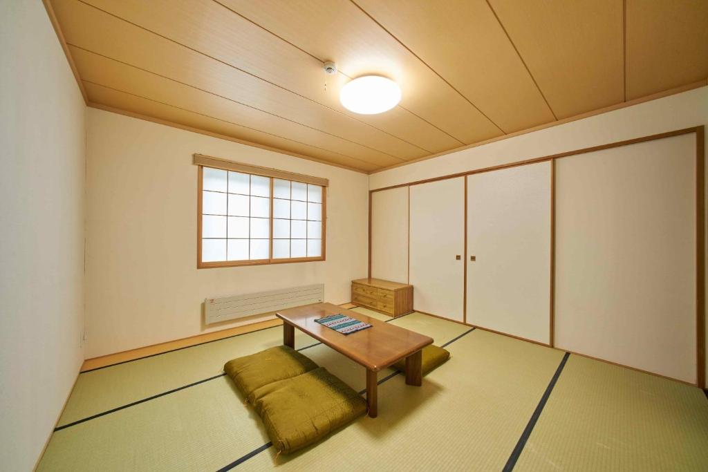 札幌的住宿－Guest House Kingyo - Vacation STAY 14499，一间设有桌子、长凳和窗户的房间