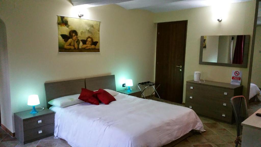 1 dormitorio con cama blanca y almohadas rojas en Bed and Breakfast Giaveno, en Giaveno