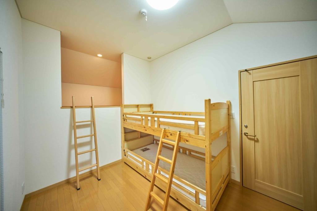 a room with two bunk beds and a closet at Guest House Kingyo - Vacation STAY 14498 in Sapporo