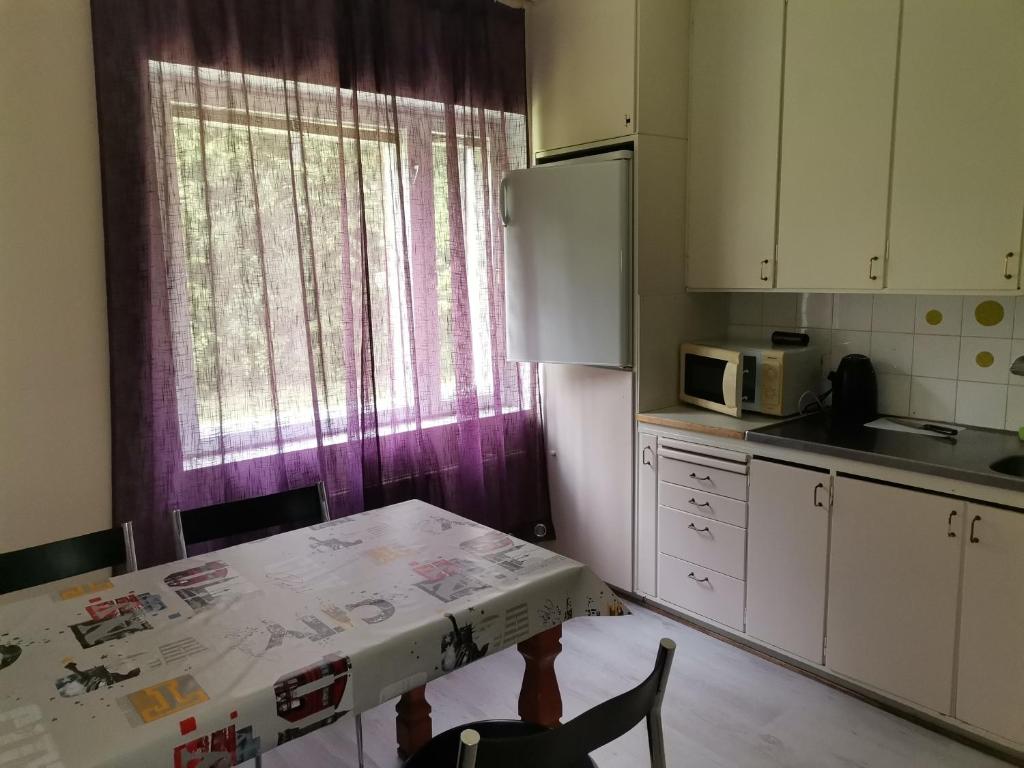 cocina con mesa y ventana púrpura en Budget housing en Kouvola
