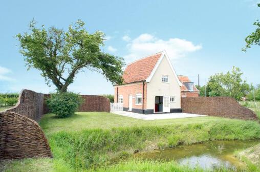 ein Haus auf einem Feld mit einem Baum und einem Teich in der Unterkunft The Cross Wing, High Ash Farm in Peasenhall