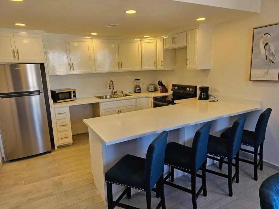 eine Küche mit einer großen weißen Theke und blauen Stühlen in der Unterkunft Pueblo Townhouse By Monte vista in Puerto Peñasco