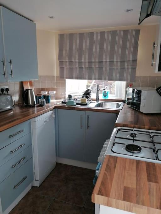 a kitchen with white cabinets and a stove top oven at Miller's Cottage in Lancaster in Lancaster