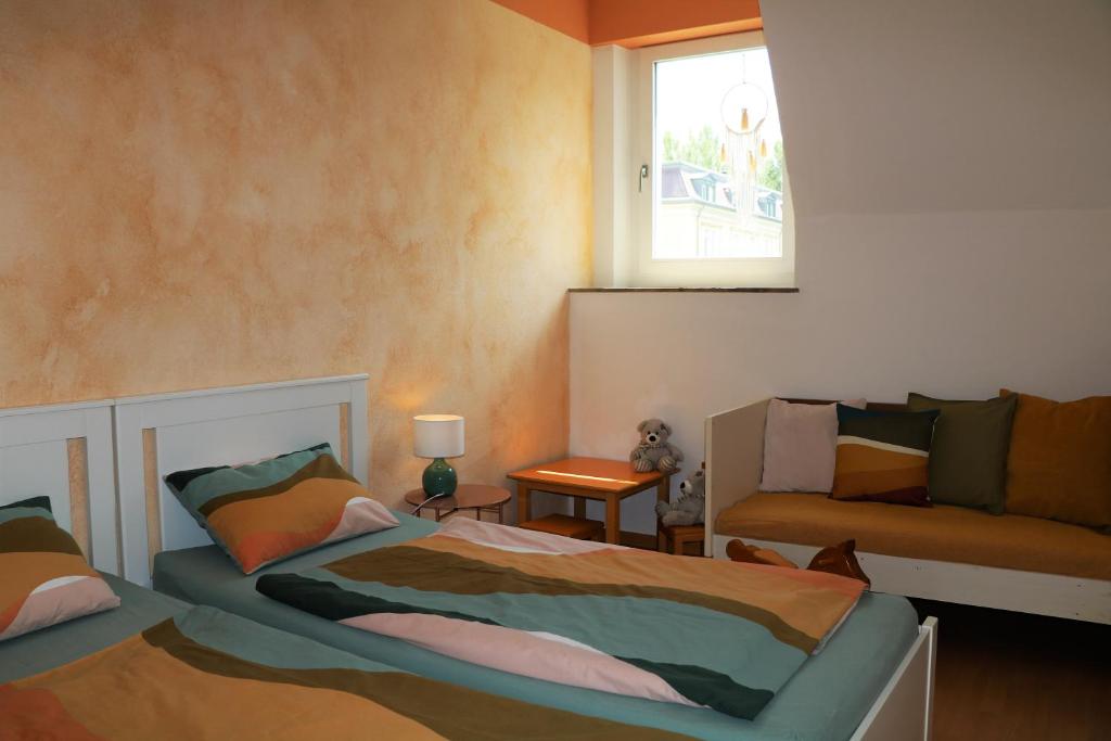 - une chambre avec 2 lits, une fenêtre et un canapé dans l'établissement 3-Zimmer-Appartement in Privatvilla, Meran Zentrum, Kostenloser Parkplatz mit Gästekarte, à Merano