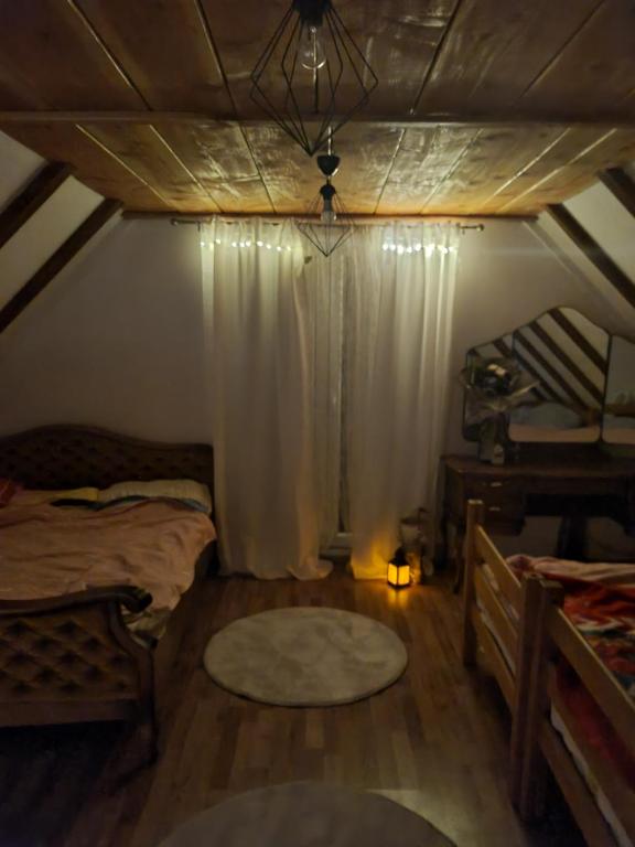 um quarto no sótão com 2 camas e uma janela em MLINSKA em Busovača