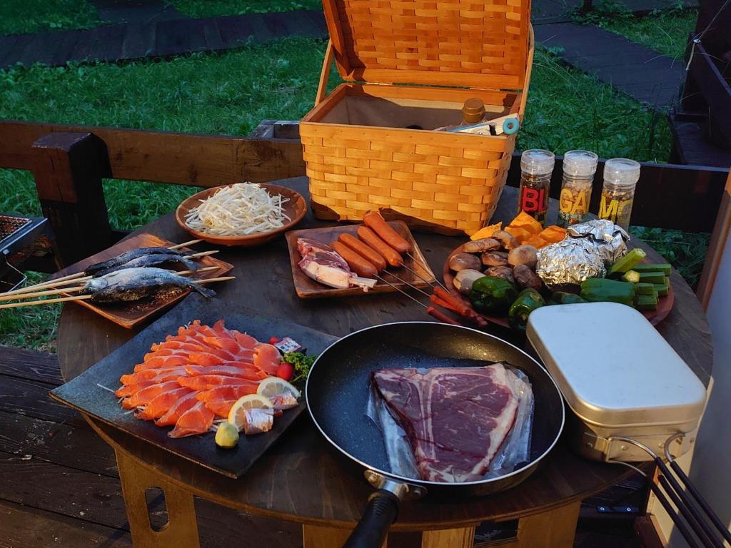 a table with meat and vegetables and a pan on it at Minamiaso STAYHAPPY - Vacation STAY 57852v in Shimoda