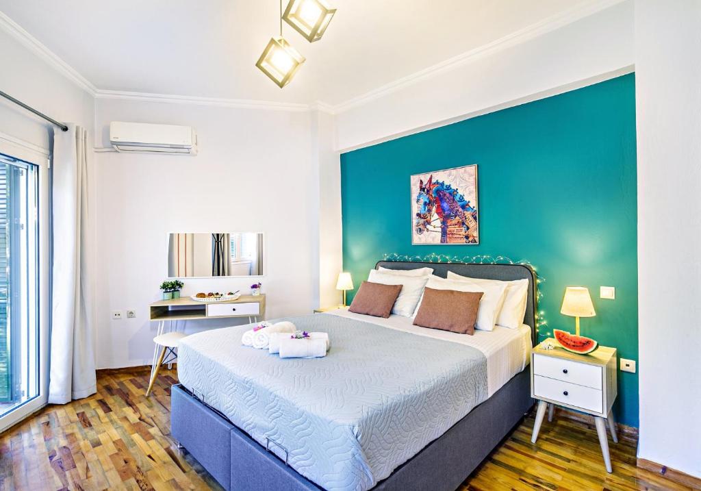 una camera con un grande letto con una parete blu di Ionian Citizen Suite a Città di Corfù
