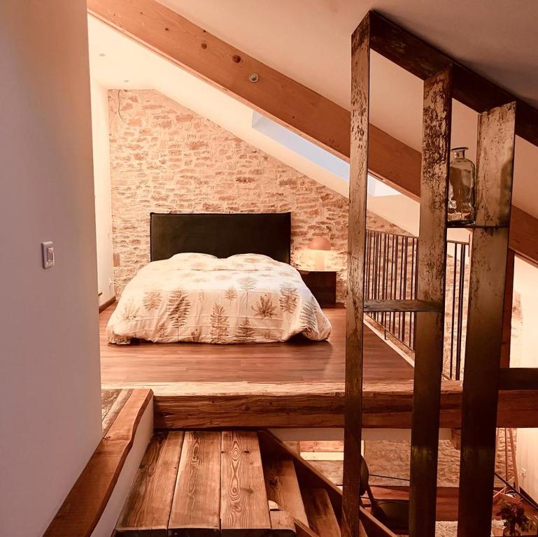 a bedroom with a bed and a brick wall at Domaine du Pré-Saint-Georges in Taintrux