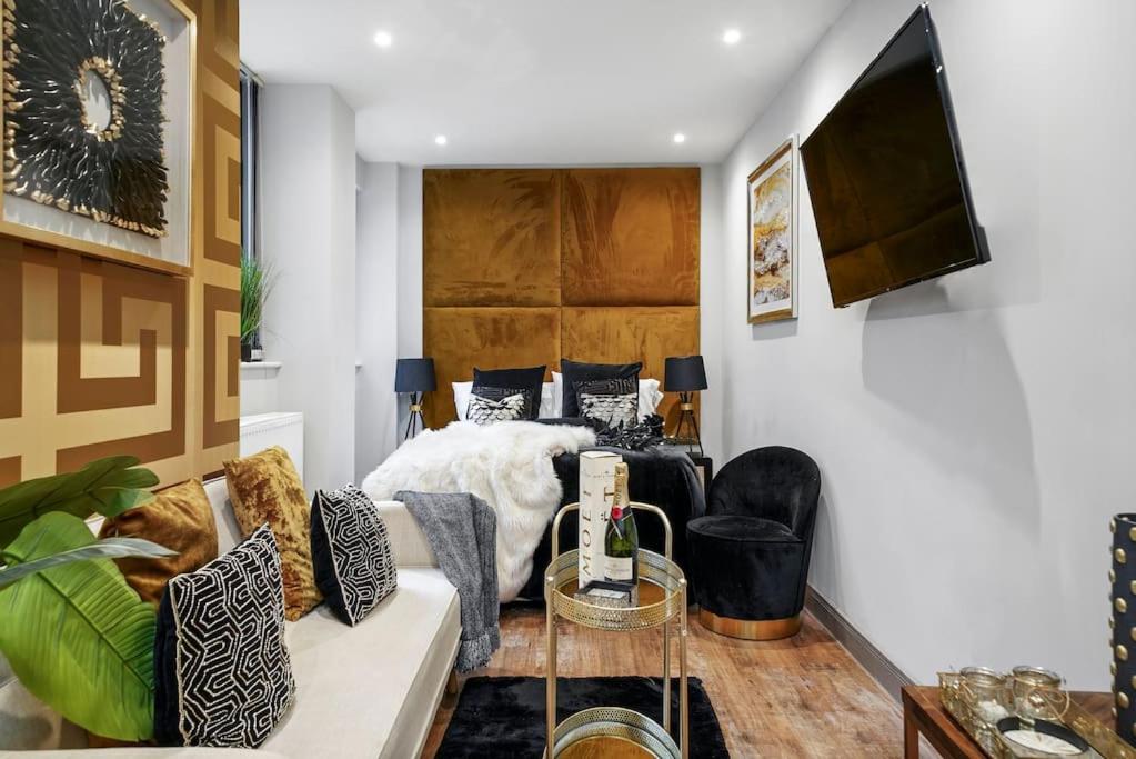 een woonkamer met een bed en een bank bij Platinum Gold Court Modern Apartment in Kent