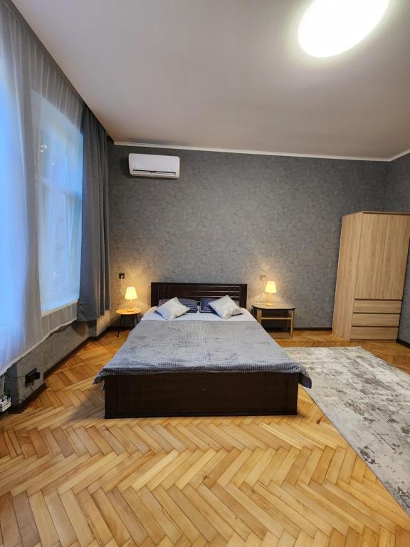 a bedroom with a large bed and two tables at O.O.APART.2 in Chernivtsi