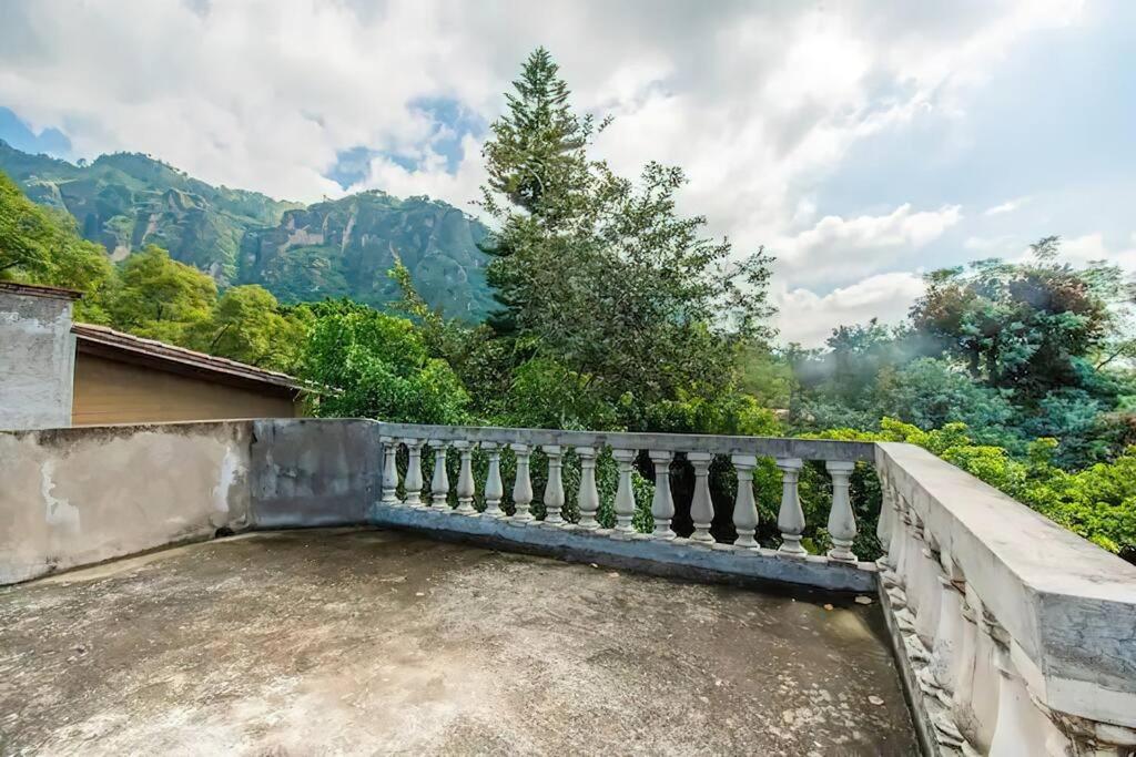 um banco de pedra sentado numa varanda com vista para as montanhas em Hermosa casa en Tepoztlán Morelos - Valle de Atongo em Tepoztlán
