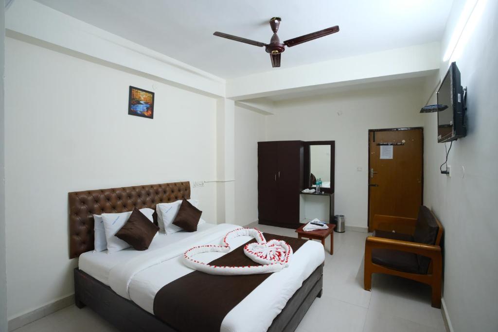 a bedroom with a bed and a ceiling fan at Ganesh Guest House in Chennai