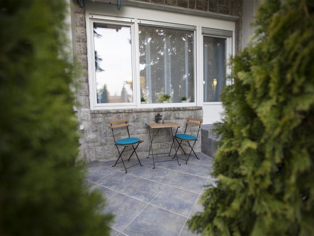a patio with chairs and a table in front of a window at Feels Like Home Apartments in Zagreb