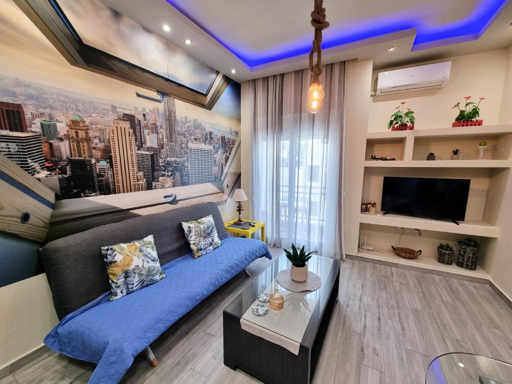sala de estar con sofá azul y TV en Betty's central apartment, en Alexandroupoli
