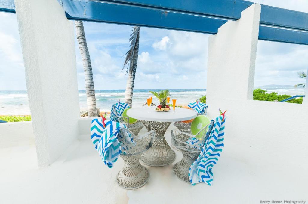 a patio with a table and chairs on the beach at Gorgeous Ocean Views! Welcome to Bella Breeze! BeachFront 2BR 2BA in Sion Farm