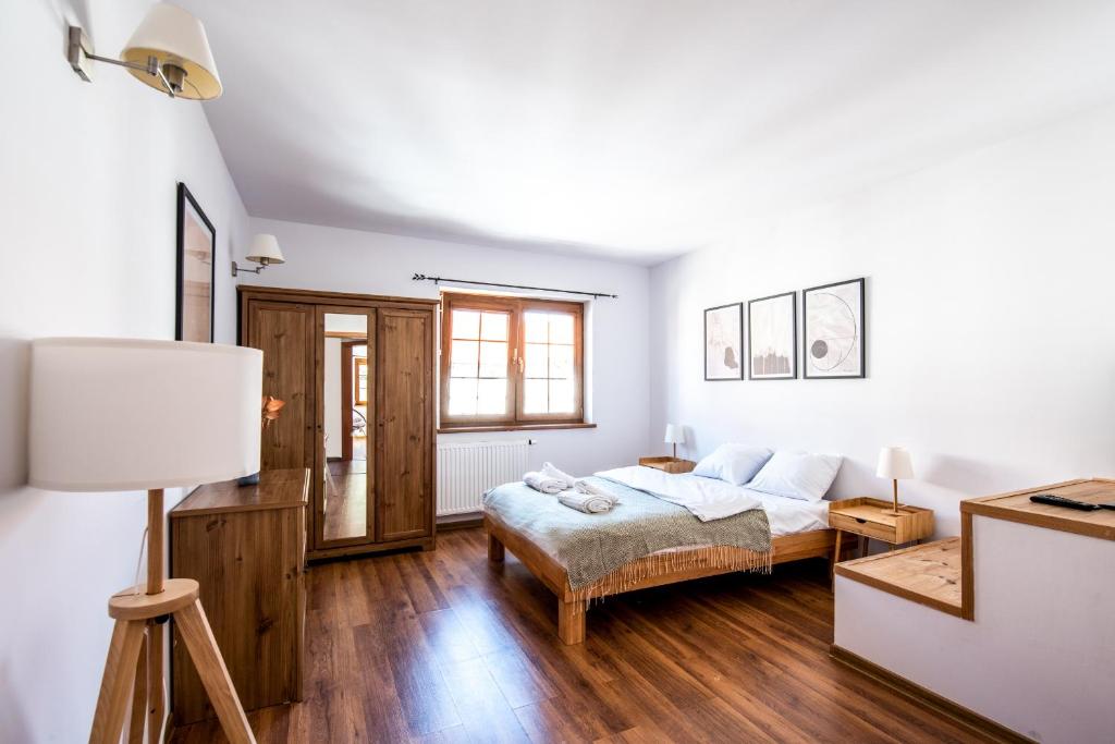 a white bedroom with a bed and a lamp at Bahia Rogowo in Rogowo