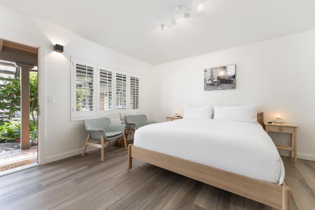 a white bedroom with a bed and a table and chairs at The Franciscan Hotel in Santa Barbara