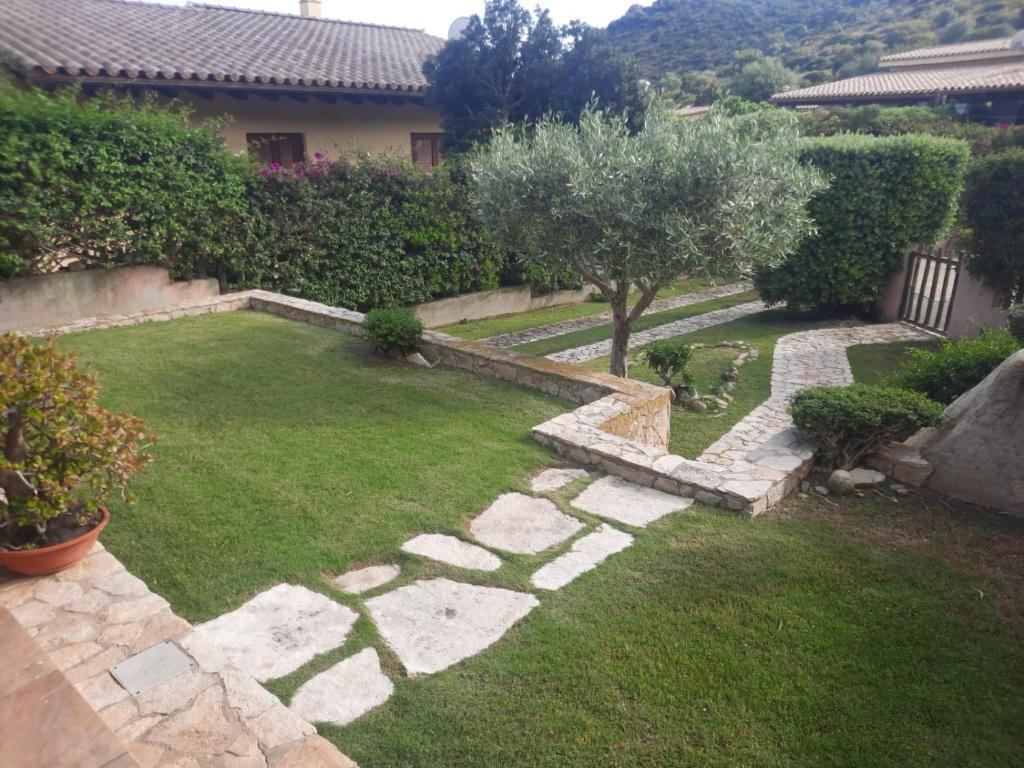 维拉西米乌斯Casa Pepe Confortevole villetta con giardino a 2 min dal mare的庭院中带石头走道的花园