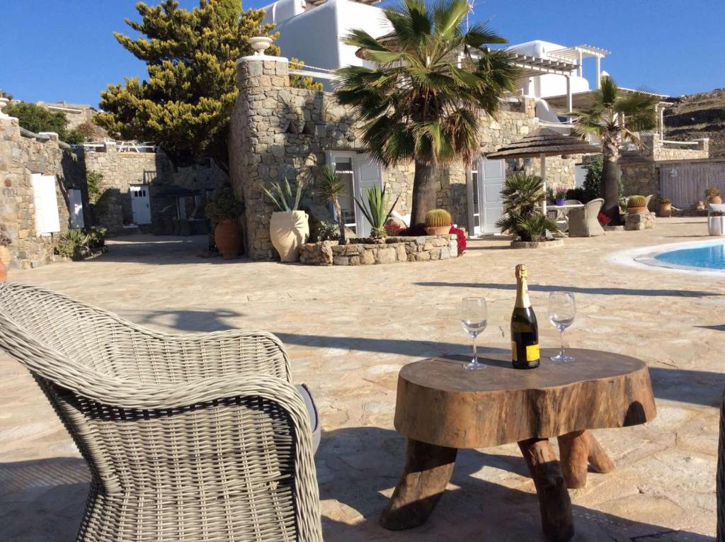 a bottle of wine and two glasses on a table at Navy Blue Suites in Ornos