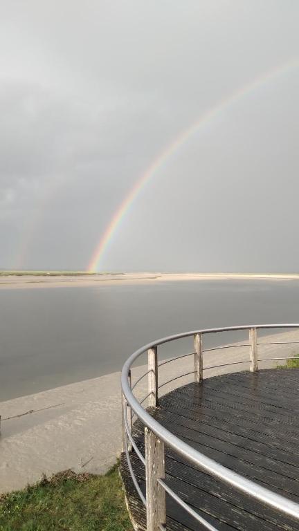 een regenboog over een lichaam van water met een hek bij chez margaut in Saint-Valery-sur-Somme
