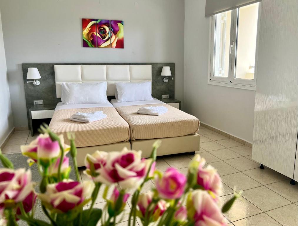 1 dormitorio con 1 cama con flores rosas en el primer plano en Maria Hotel Sisi, en Sissi