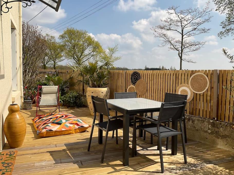 Un patio con una mesa y sillas en una terraza. en Havre de paix à Carteret !, en Barneville-Carteret