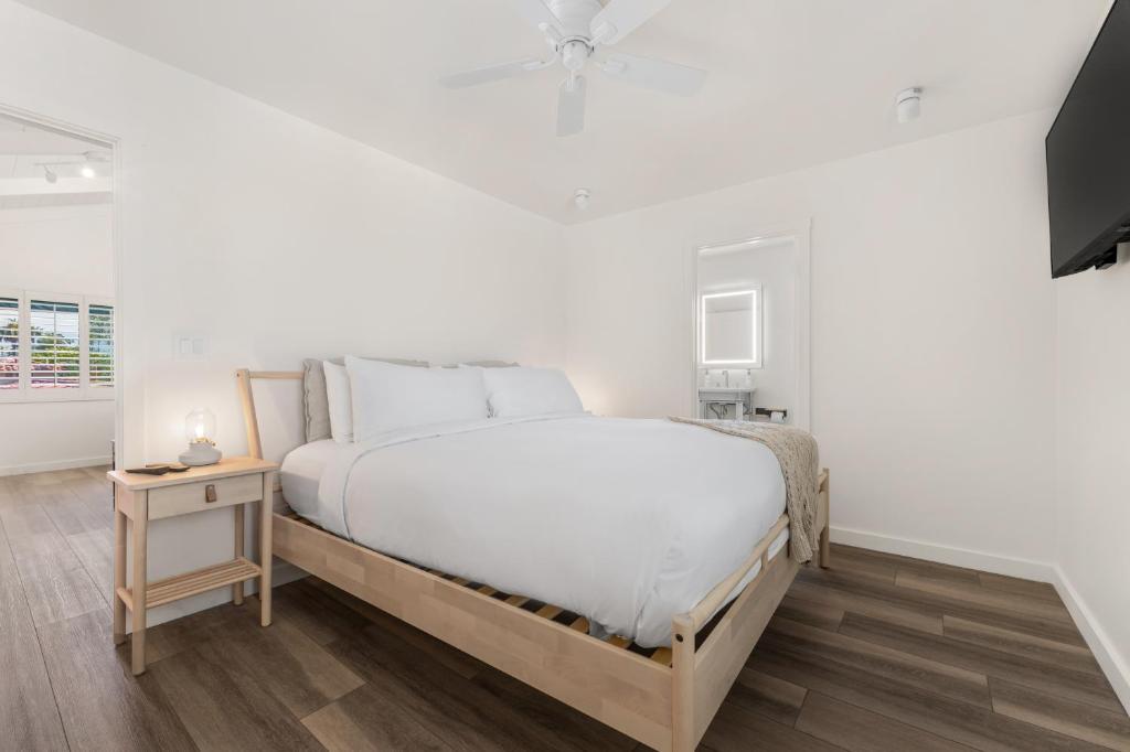 a white bedroom with a bed and a ceiling fan at The Franciscan Hotel in Santa Barbara