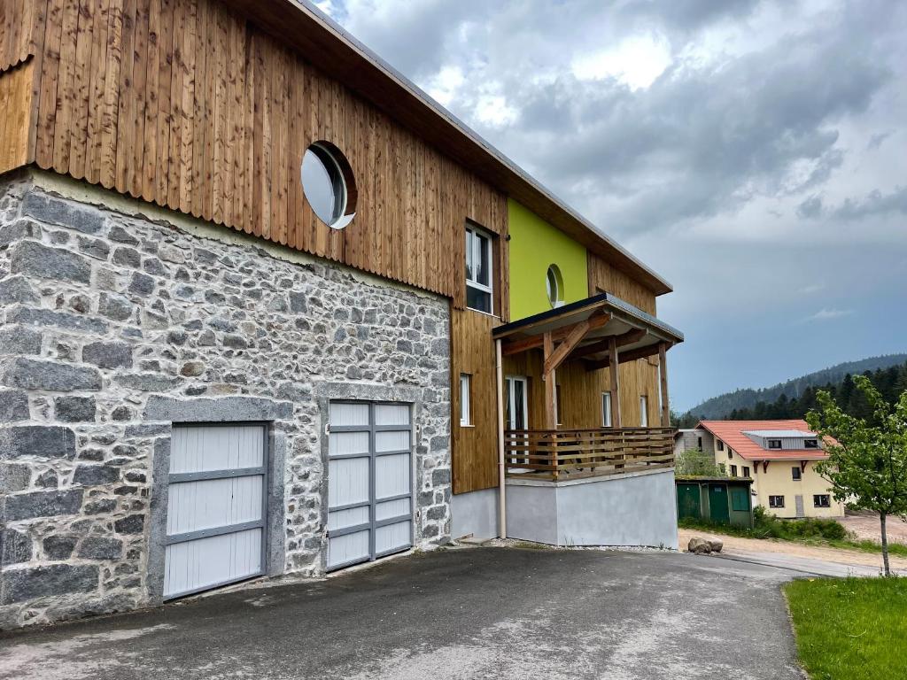 a barn with a garage and a building at Les gîtes de la bergerie in Xonrupt-Longemer