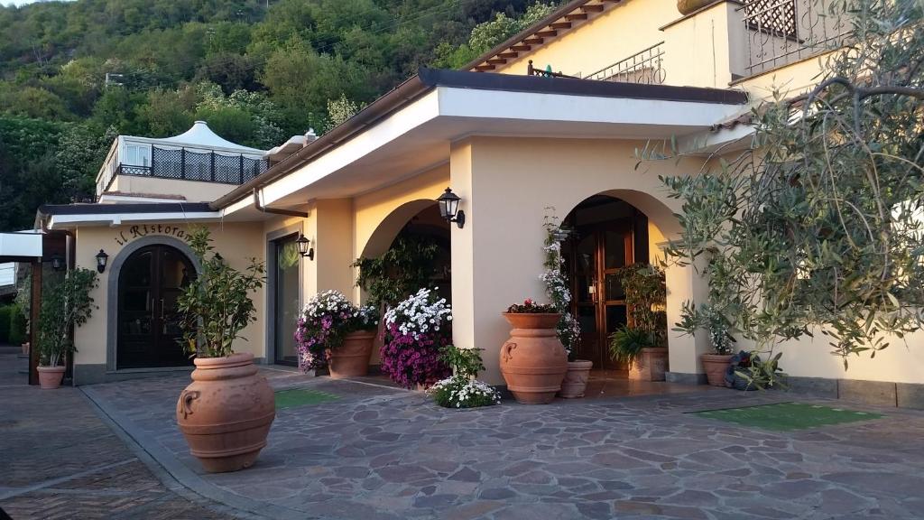 un edificio con grandi vasi di piante di fronte ad esso di Hotel Villa Degli Angeli a Castel Gandolfo