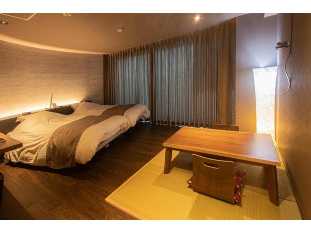 a bedroom with a bed and a wooden table at Oita Onsen Business Resort Kyuan - Vacation STAY 50166v in Oita