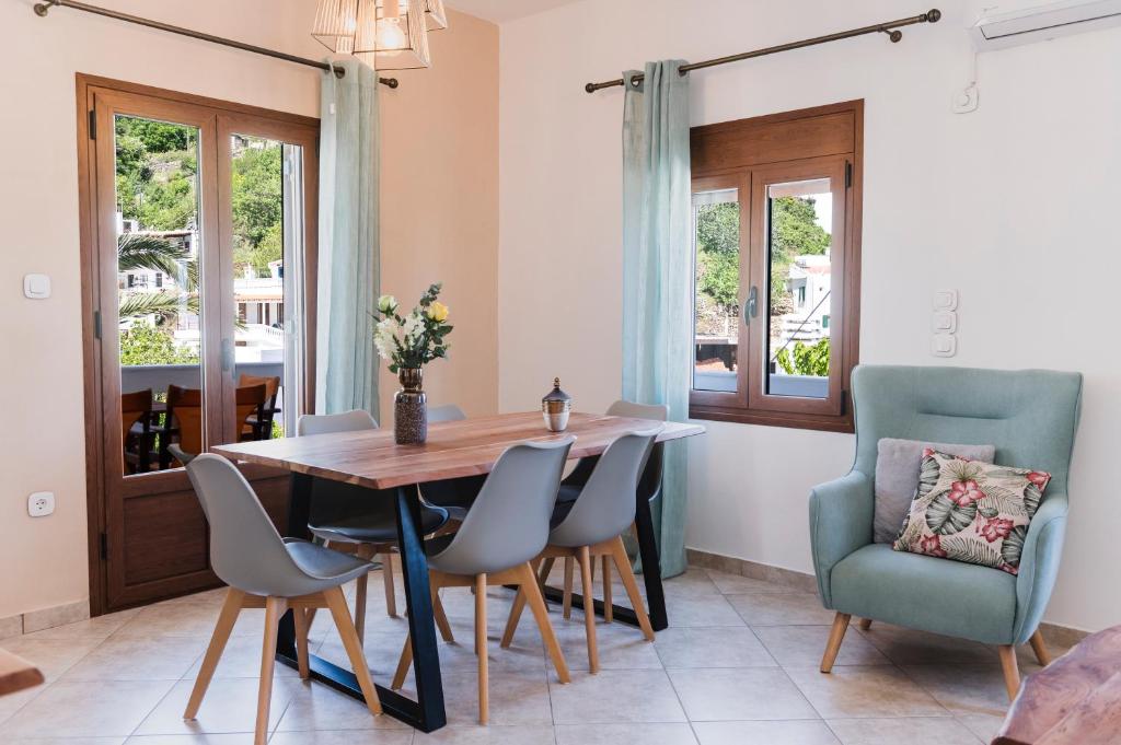 una sala da pranzo con tavolo e sedie in legno di koronos village apartments a Kóronos