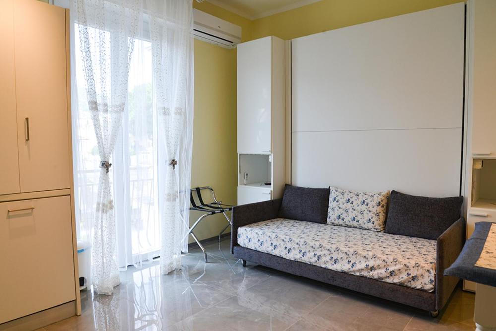 salon z kanapą i oknem w obiekcie la maisonnette di anna w mieście Arma di Taggia