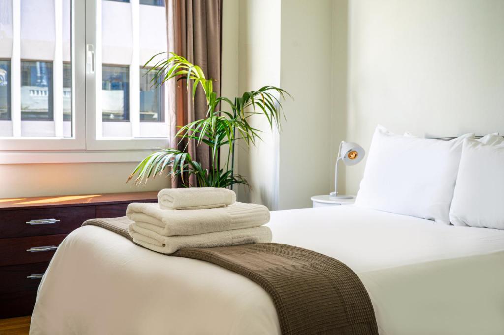ein Schlafzimmer mit einem Bett mit Handtüchern und einer Pflanze in der Unterkunft Acropolis, Falirou in Athen