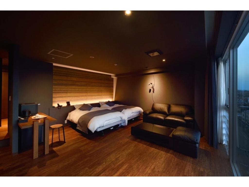 a bedroom with a large bed and a couch at Oita Onsen Business Resort Kyuan - Vacation STAY 50162v in Oita