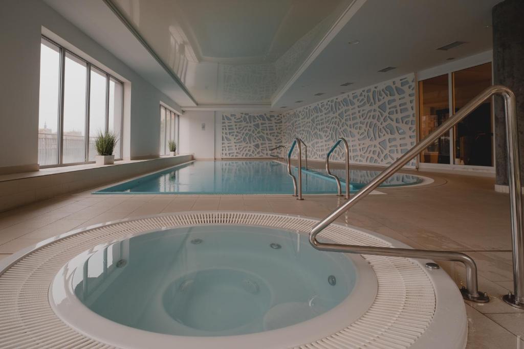 a large pool with a hot tub in a building at TOTU HOME Waterlane Island Apartments in Gdańsk