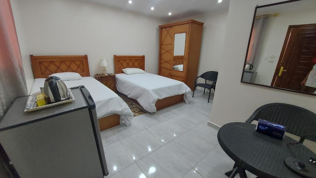 Habitación de hotel con 2 camas y mesa en Ramses Guest House en El Cairo