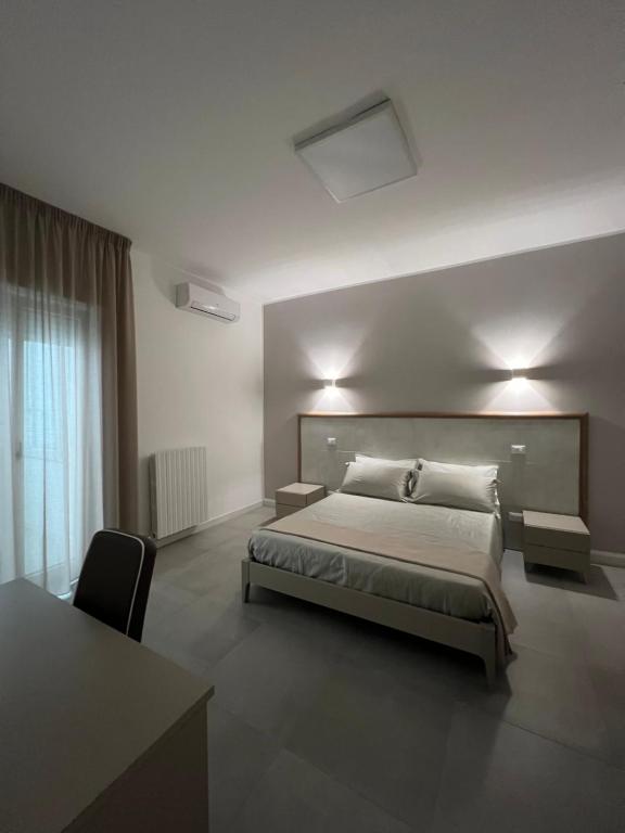 a bedroom with a bed and a desk and a table at Stanze d’Autore in Taranto